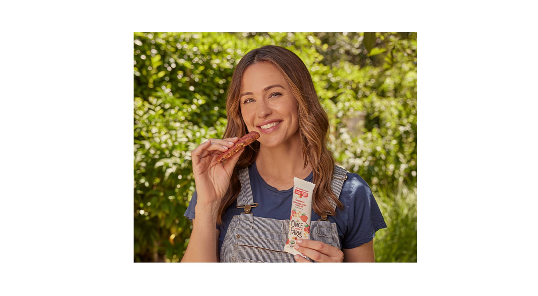 Image of co-founder, Jennifer Garner eating a Strawberry Refrigerated Oat Bar