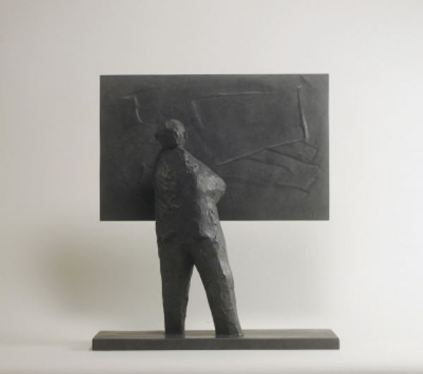 bronze sculpture of a man looking at a picture