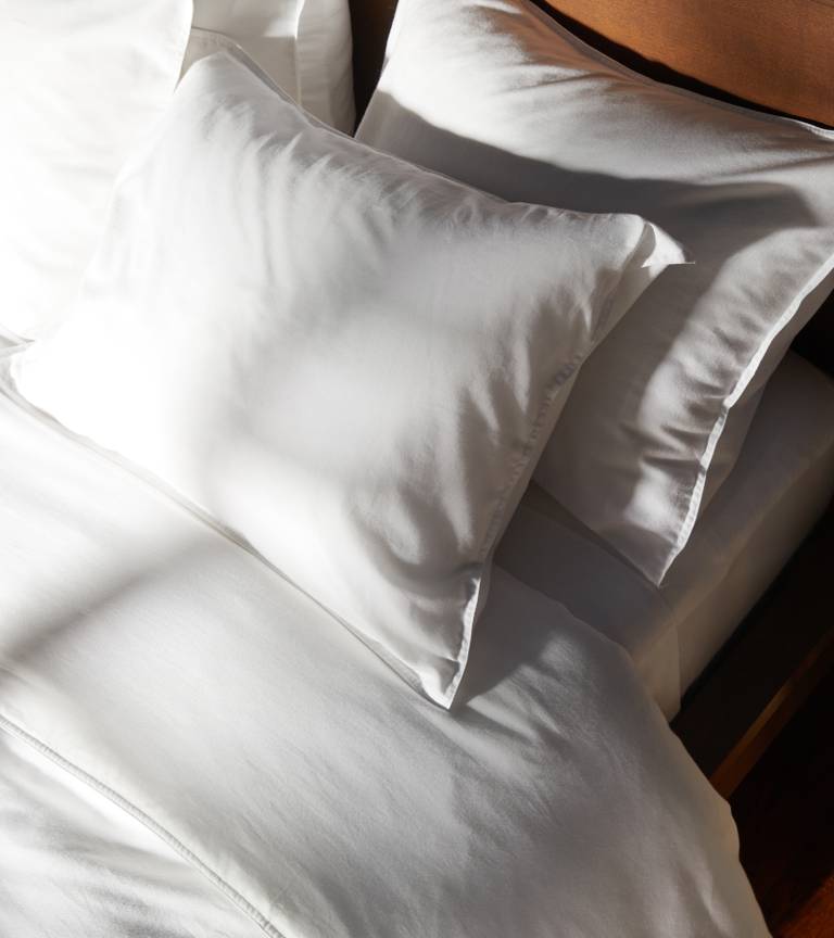 White Heathered Cashmere sheets on a sun-drenched bed