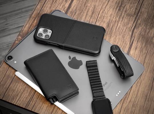 Aluminum slim wallet, Ekster key holder, Apple Watch and iPhone sitting on top of a iPad