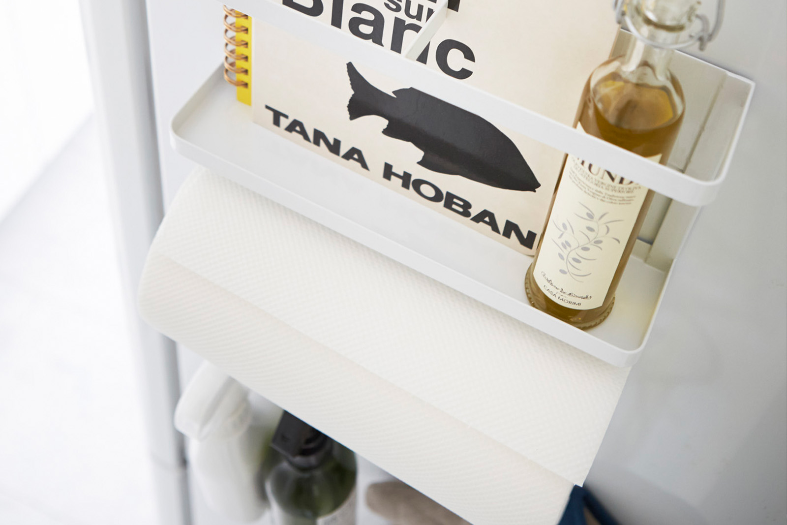 Aerial view of white Magnetic Storage Caddy holding oil bottle, book, and paper towel by Yamazaki Home.
