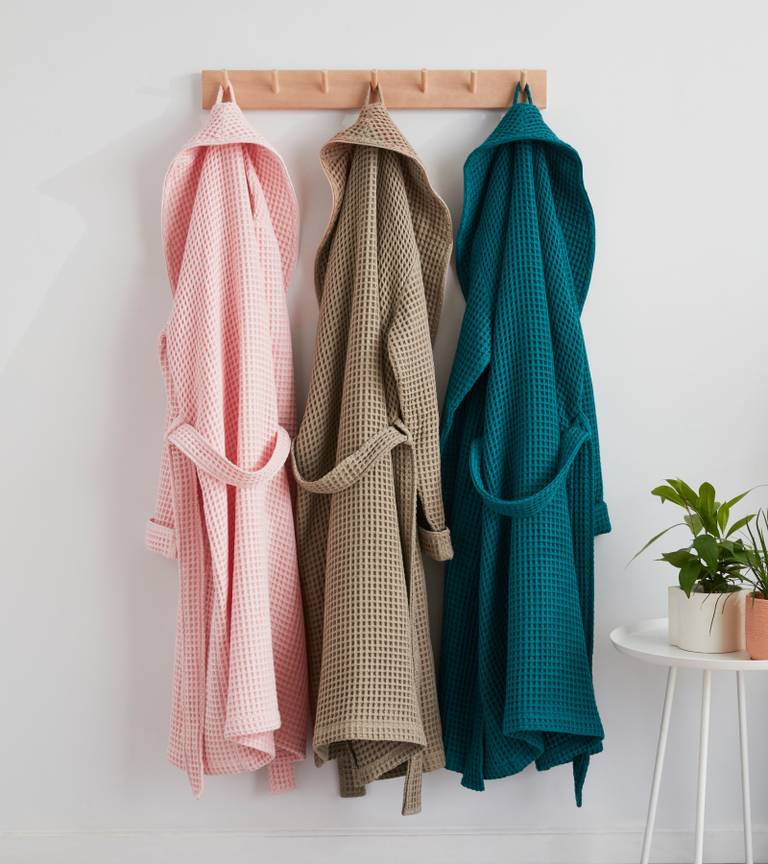 Wall-mounted clothing hanger featuring new colors of our Waffle Robe in Flamingo, Dark Caramel, and Ink Blue.