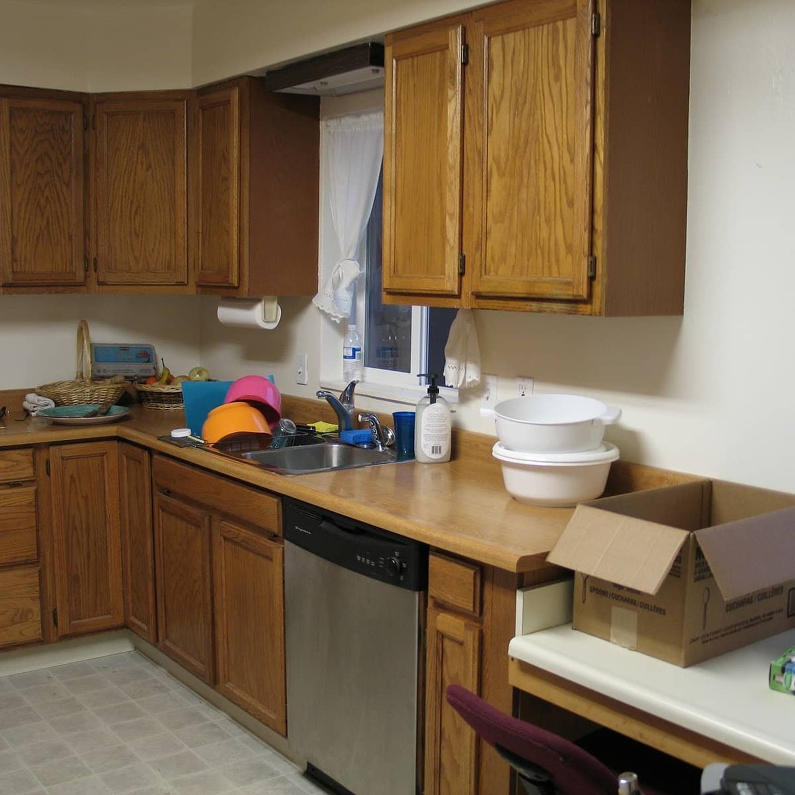 View of kitchen before renovated, bowls and soap at a kitchen sink. 