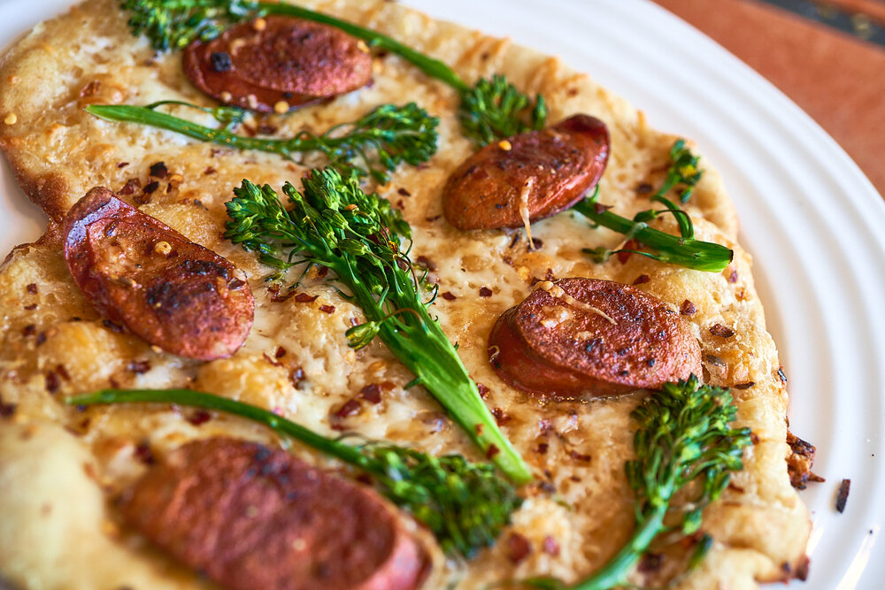 White broccolini & sausage pizza made with Sonoma Gourmet's sauteed garlic olive oil