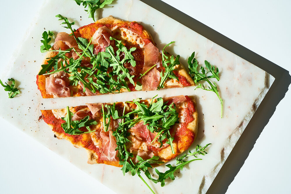 Prosciutto arugula pizza made with Sonoma Gourmet's heirloom tomato pizza sauce and basil parmesan olive oil
