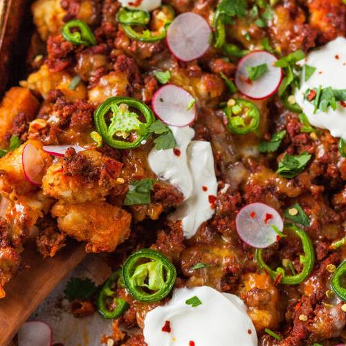 Sheet-pan totchos made with Sonoma Gourmet's cherry tomato basil sauce and sauteed garlic olive oil