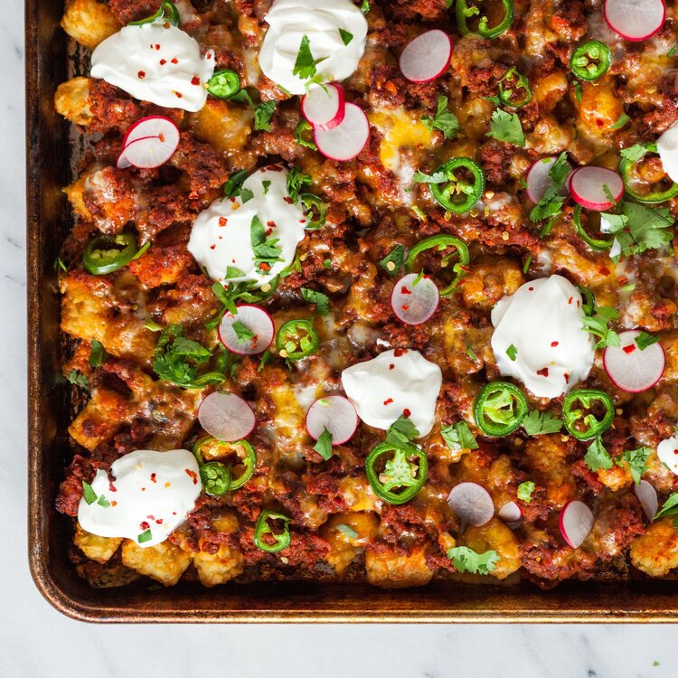 Sheet-pan totchos made with Sonoma Gourmet's cherry tomato basil sauce and sauteed garlic olive oil