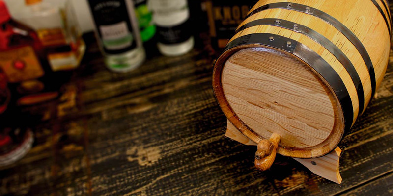 Small oak aging barrel on a stand with spigot attached