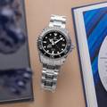 Grand Seiko SBGA229 wristwatch - a titanium cased, black dial diver atop a brown table. 