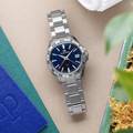 Grand Seiko SBGN005 - blue dial stainless steel wristwatch atop a table. 