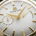 A yellow gold Grand Seiko timepiece with a light dial, and gold-tone hands and indexes. 