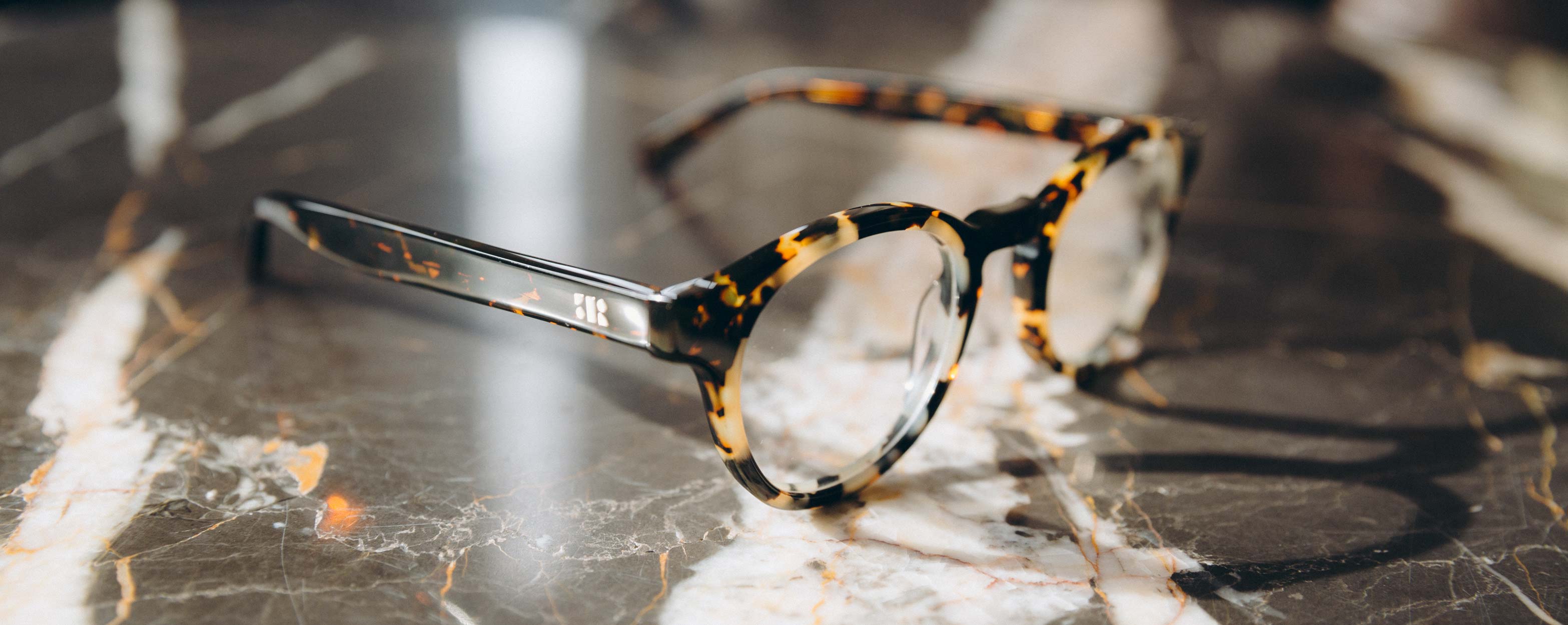 Photo Details of Alexis Tortoise & Grey Marble Reading Glasses in a room