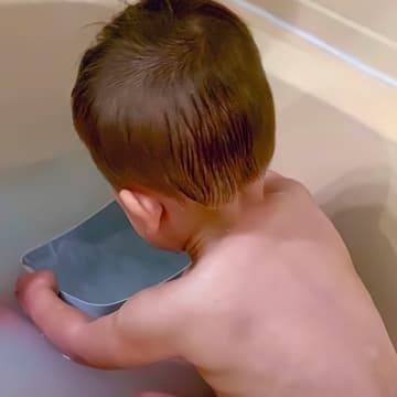young child in bath with no sign of eczema on his back