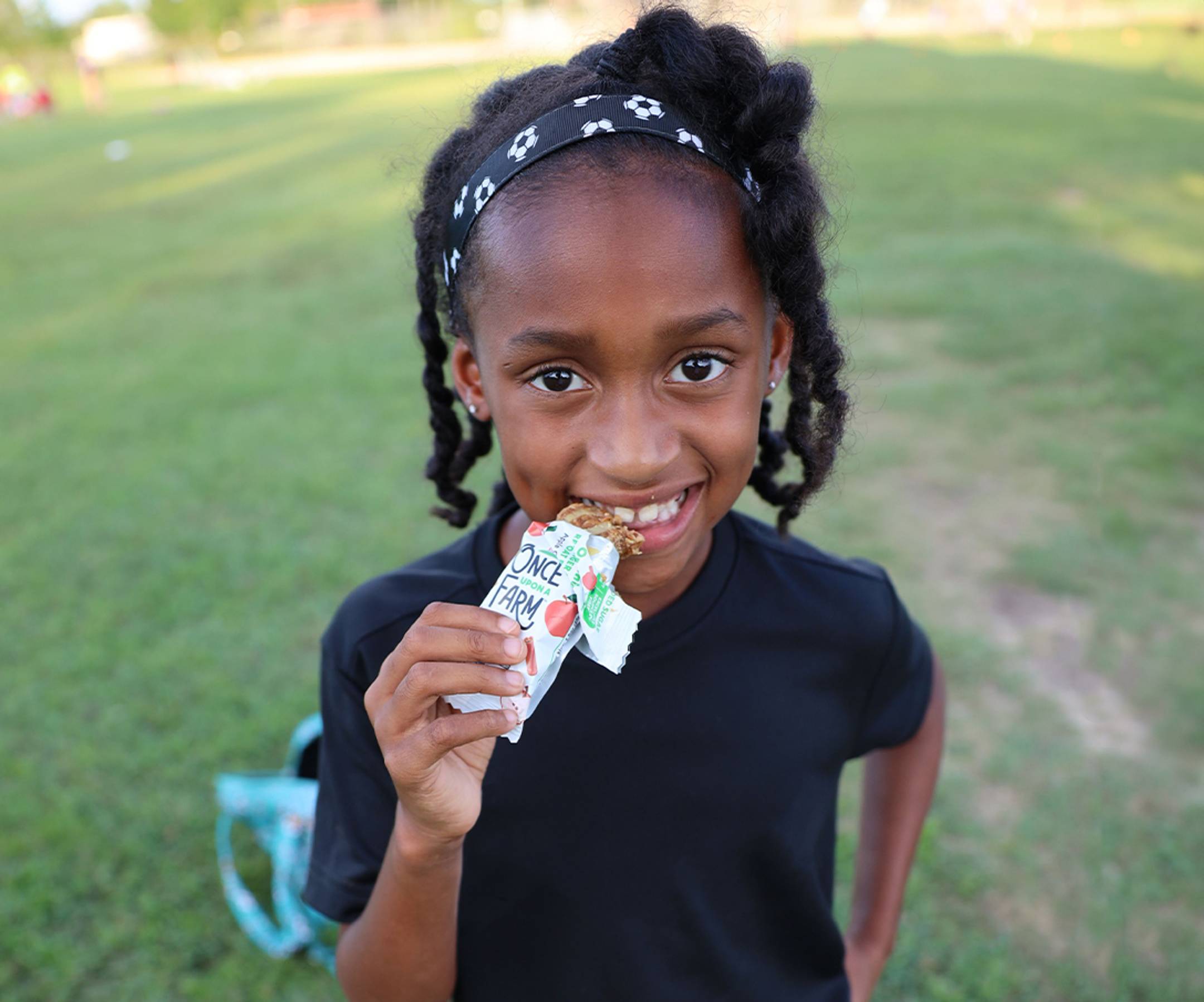 photo of a young girl eating a refrigerated oat bar before sports practice