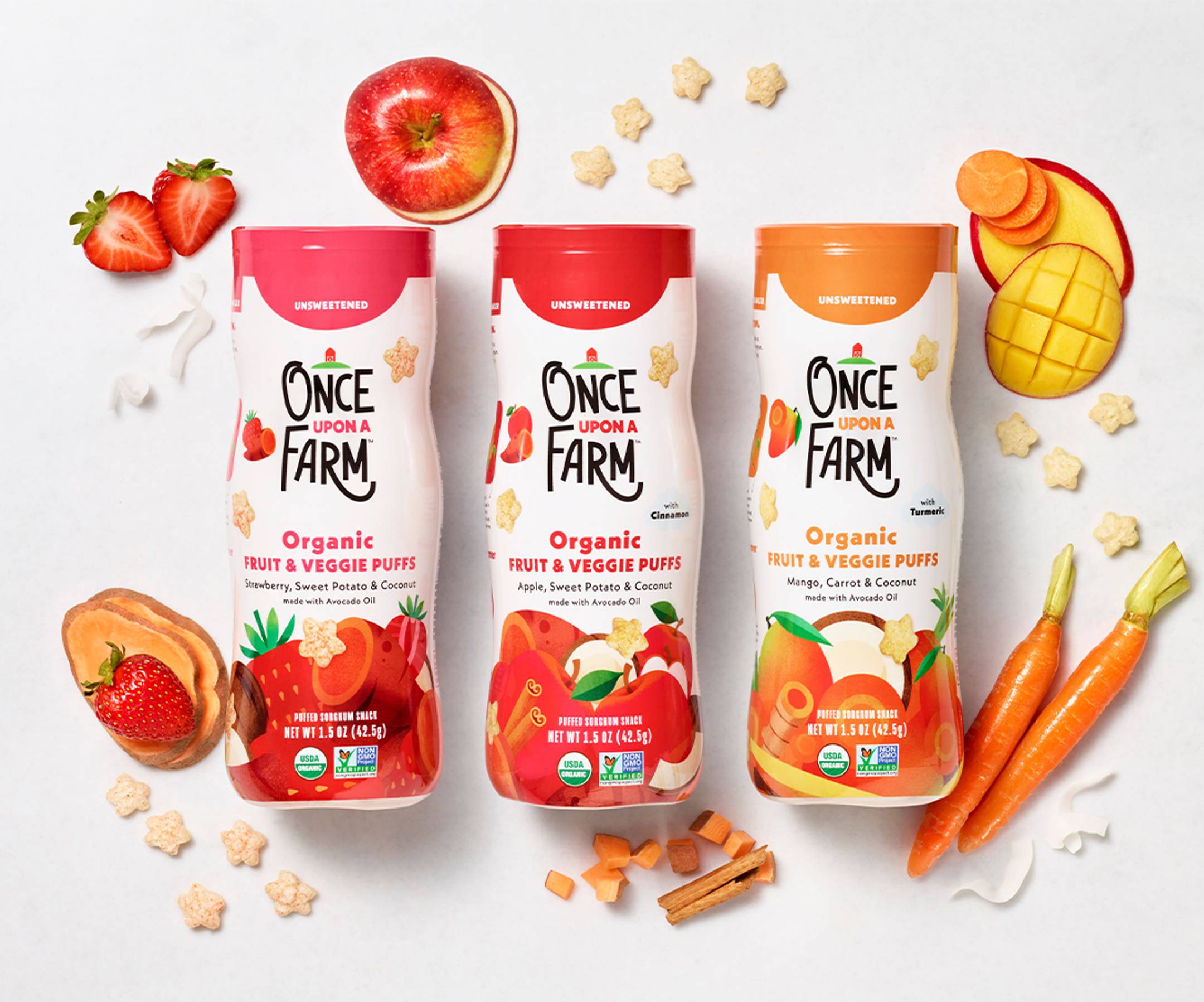 Image of our new baby & toddler pantry snack - fruit & veggie puffs shot in a studio in 3 flavors: Strawberry, Sweet Potato & Coconut, Apple, Sweet Potato & Coconut, and Mango, Carrot & Coconut. With real fruit and veggie ingredients in the background. 