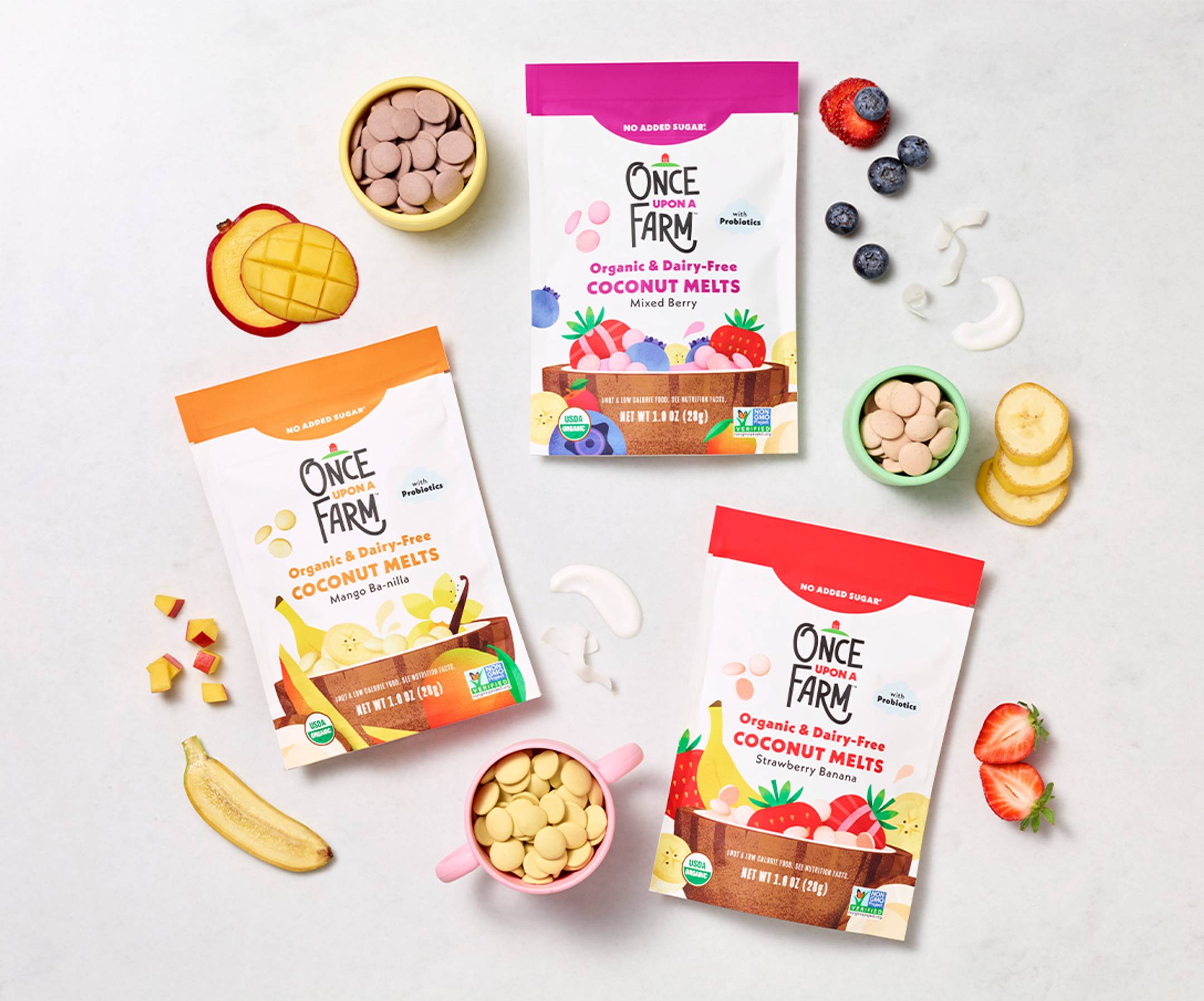 Image of our new baby & toddler pantry snack - coconut melts shot in a studio in 3 flavors: Mango Ba-nilla, Mixed Berry, and Strawberry Banana. With real fruit ingredients in the background. 