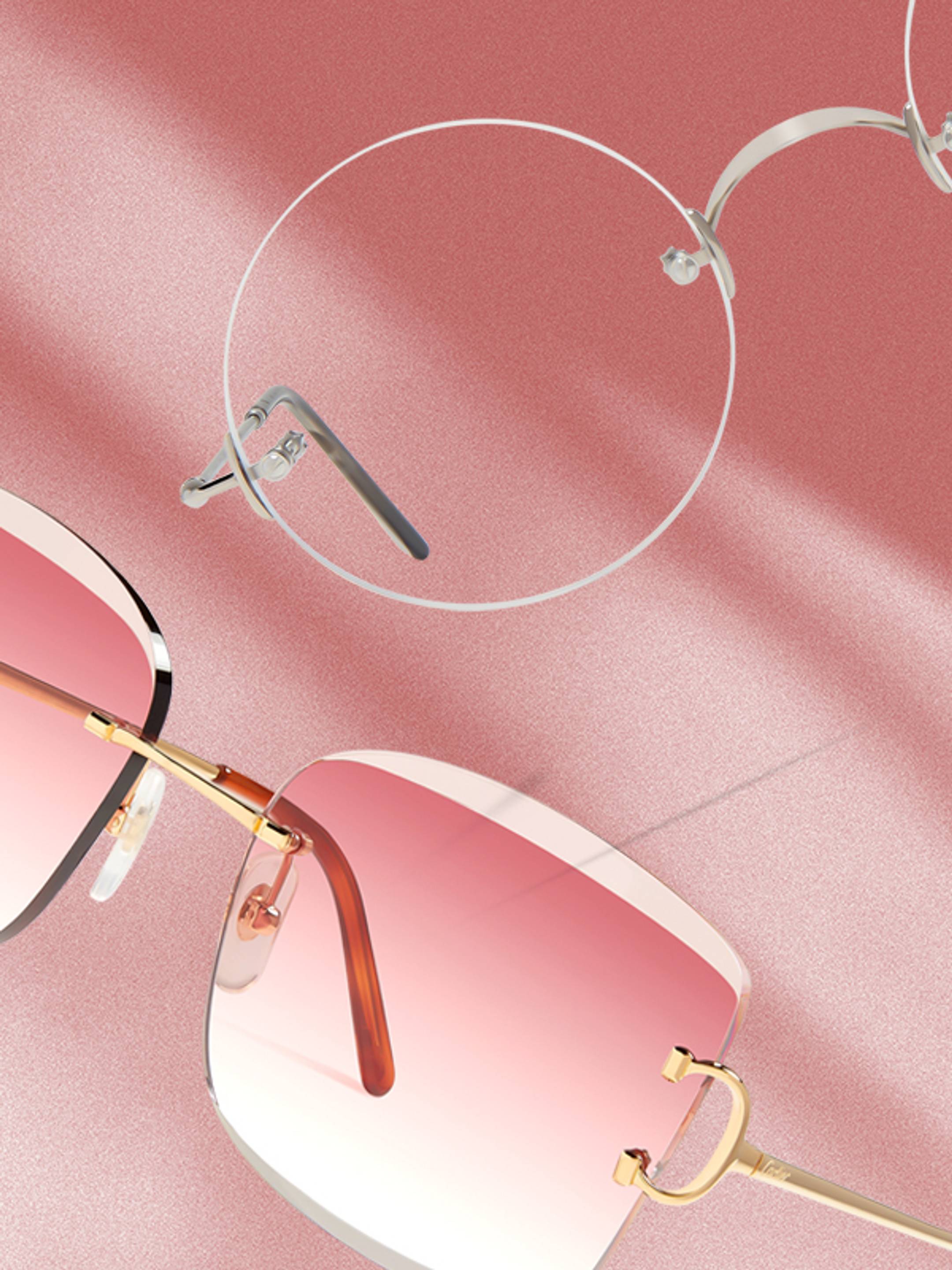 Close up of sunglasses and eyeglasses on a textured pink background