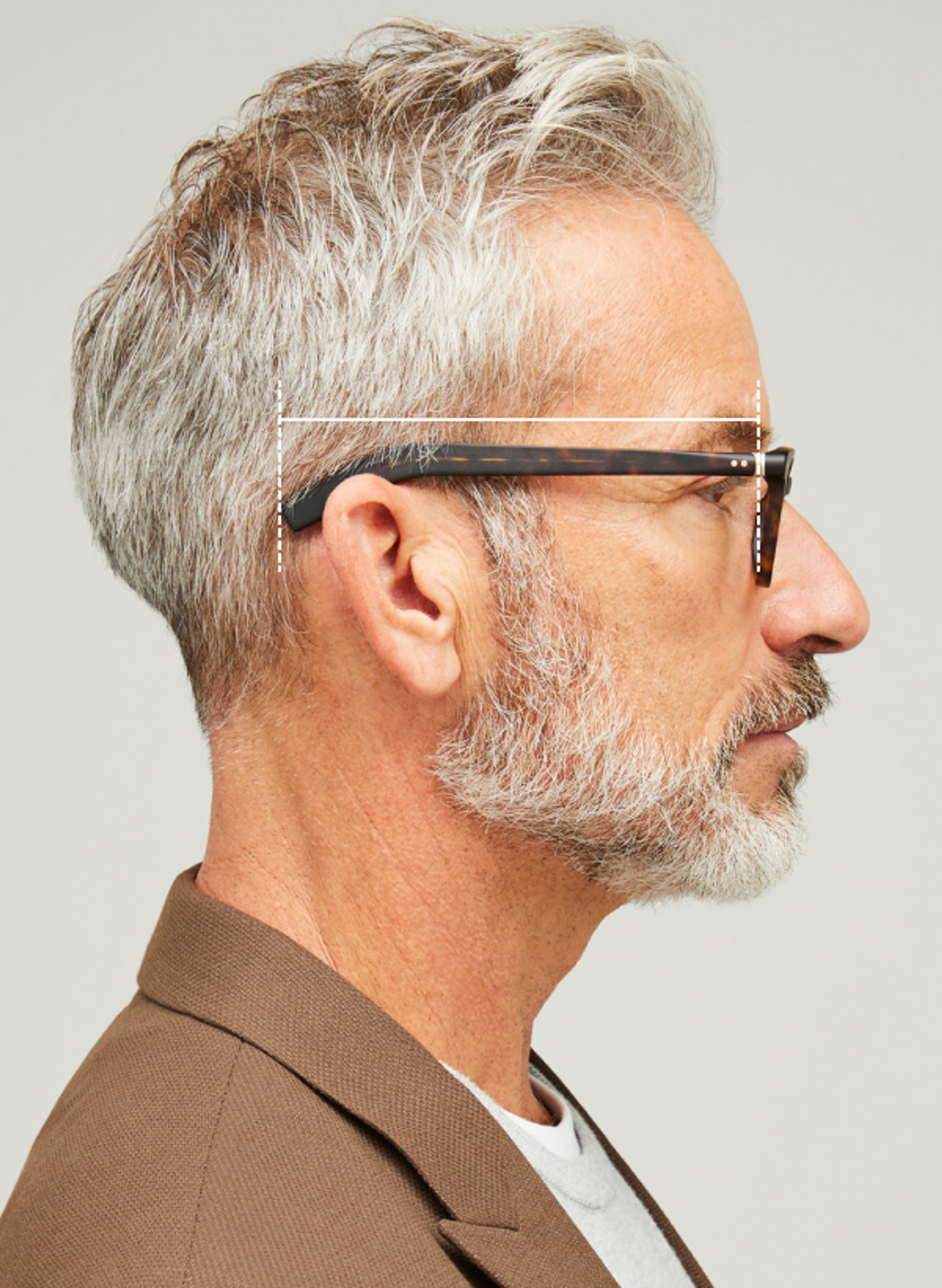 Side view of male model wearing eyeglasses with cross hairs over eyeglasses temple