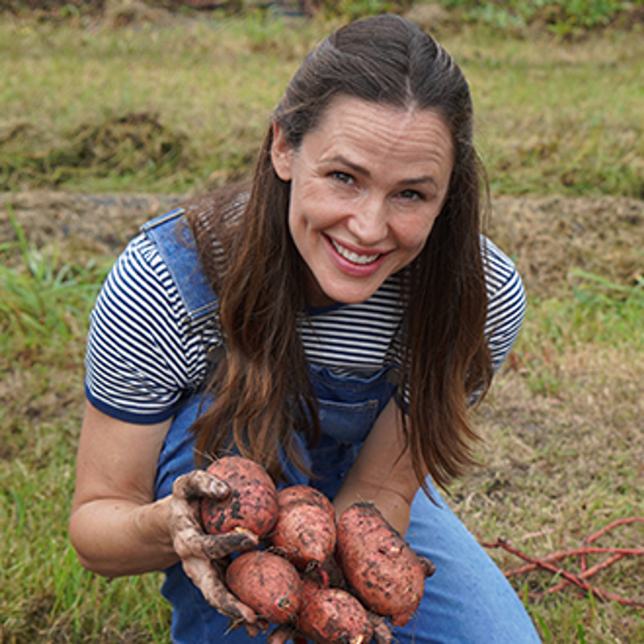 Co-founder and Chief Brand Officer Jennifer Garner holding sweet potatoes on family farm 