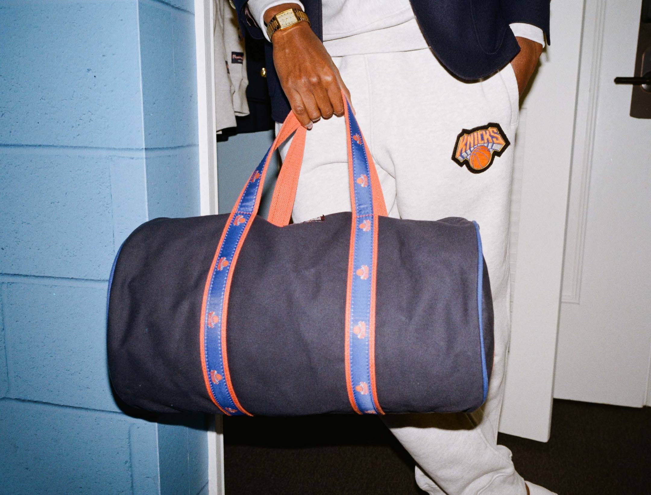 Model holding the New York Knicks Banker Bag in a dorm room.