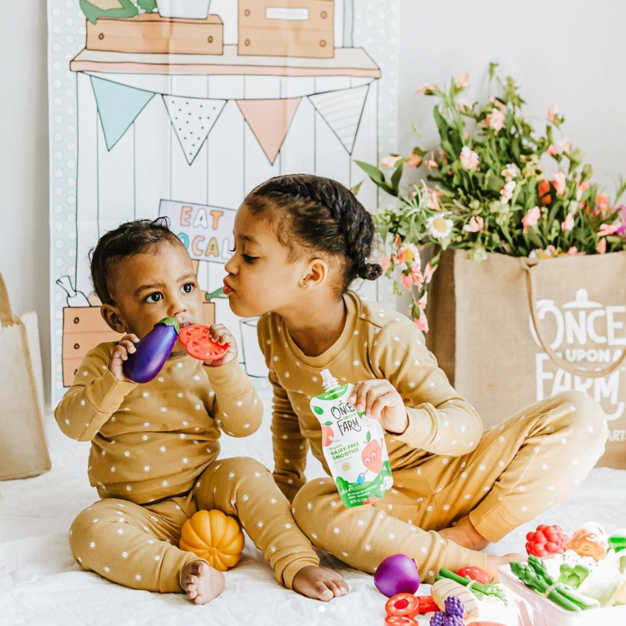 Two children eating Once Upon a Farm fruit & veggie blends